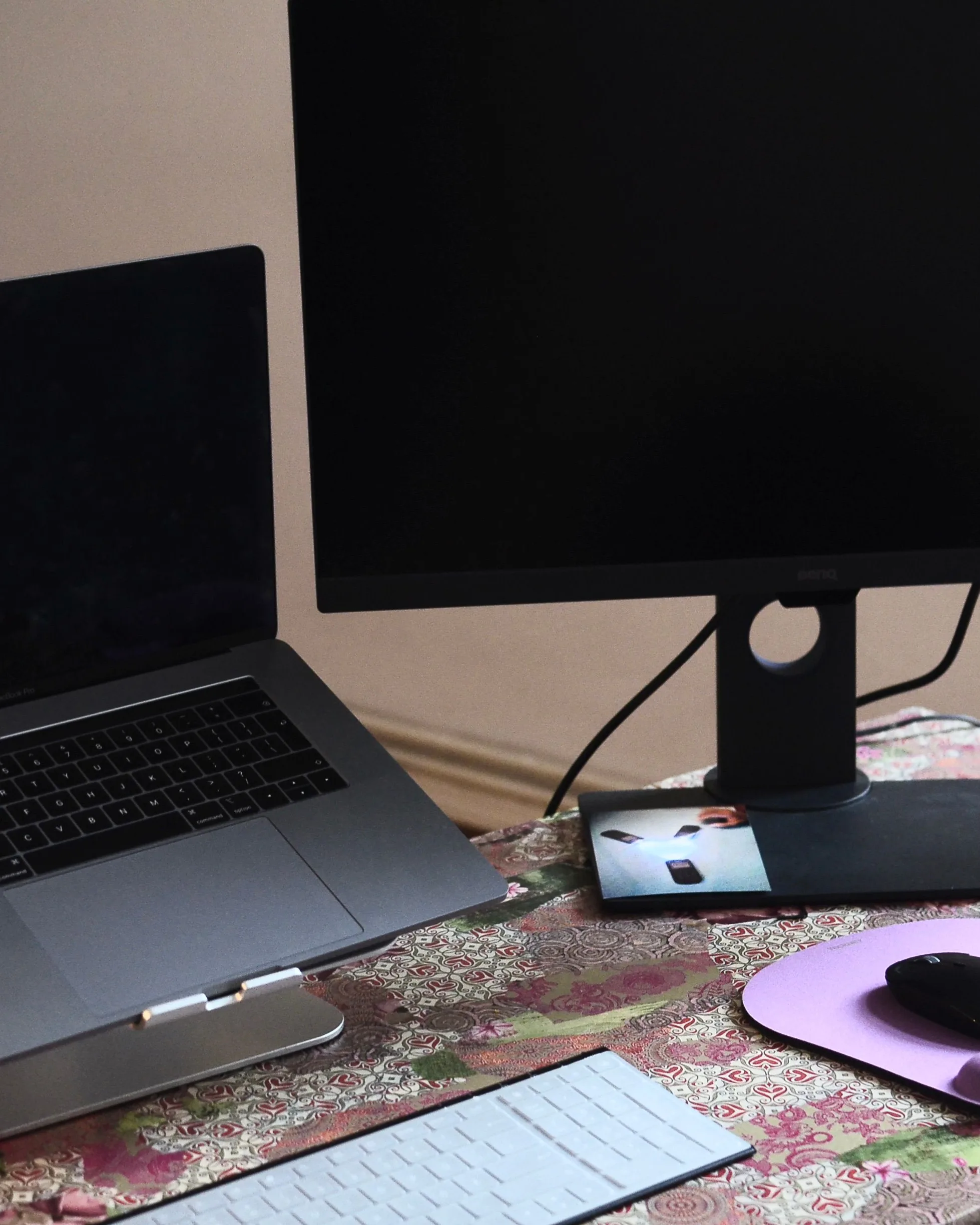 Un poste de travail : écran posé sur un rehausseur, clavier et souris devant